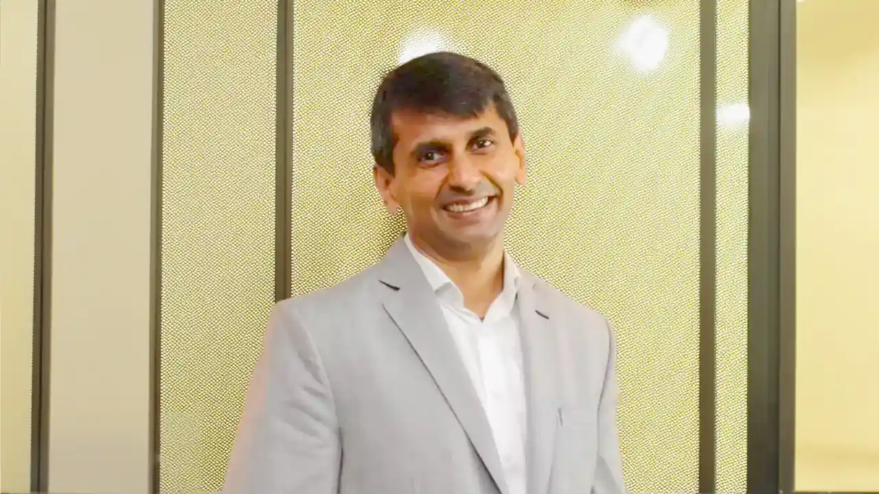 Abhinandan Lodha smiling in a light gray suit; founder of The House of Abhinandan Lodha